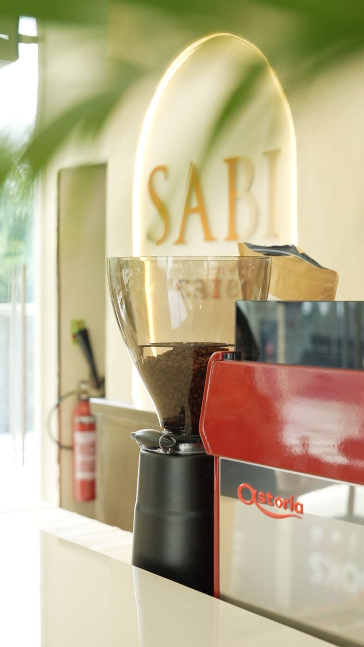 Coffee grinder in front of the glowing SABI arch